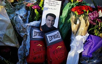 Boxing gloves and a message sit among flowers at a makeshift memorial to Muhammad Ali at the Muhammad Ali Center in Louisville, Kentucky, June 4, 2016. (AP/David Goldman)