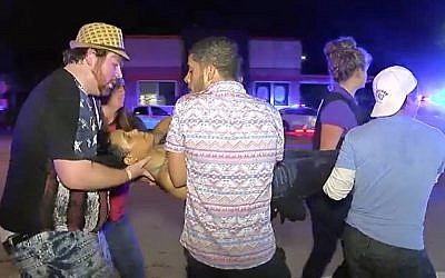 An injured person is escorted out of the Pulse nightclub after a shooting rampage, Sunday morning June 12, 2016, in Orlando, Fla. (AP/Steven Fernandez)