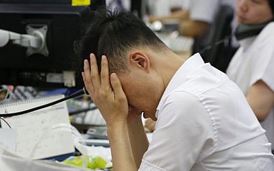 A currency trader rubs his eyes at the foreign exchange dealing room in Seoul, South Korea, Friday, June 24, 2016. (AP/Lee Jin-man)
