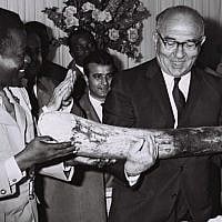 Congolese premier Gen. Leonard Mulamba gives Prime Minister Levi Eshkol an elephant tusk in a ceremony outside Kinshasa, June, 1966. (Moshe Fridan/GPO)