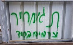 Graffiti reading 'Arabs out' and 'price tag' is sprayed on a wall in the Arab town of Abu Ghosh, near Jerusalem, on June 9, 2016 (photo credit: Israel Police)