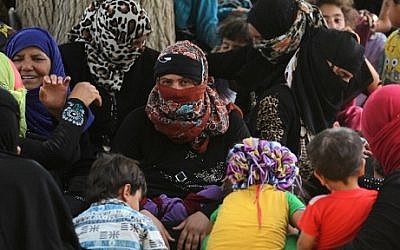 Displaced Iraqis, who fled the al-Falahat village west of Fallujah due to fighting between Iraqi government forces and the Islamic State (IS) group, wait to receive food and aid at the village of al-Azraqiyah, on June 4, 2016. AFP PHOTO / AHMAD AL-RUBAYE