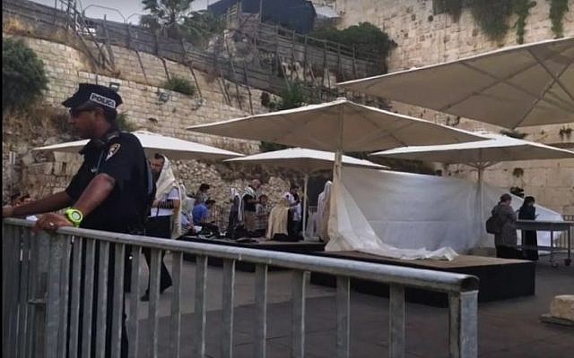 A police officer stands in front of a makeshift partition erected ahead of an Orthodox prayer service at the mixed gender Western Wall plaza on June 14, 2016. screen capture: Facebook) A police officer stands in front of a makeshift partition erected ahead of an Orthodox prayer service at the mixed gender Western Wall plaza on June 14, 2016. screen capture: Facebook)