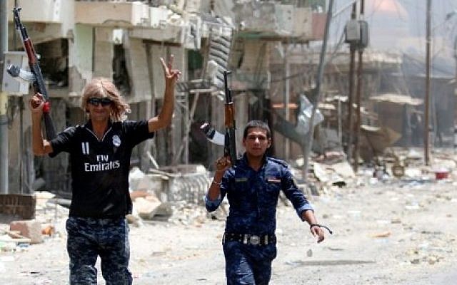 Members of Iraqi police forces celebrate on a street on June 27, 2016 in western Fallujah, 50 kilometers (30 miles) from the Iraqi capital Baghdad, after Iraqi forces retook the embattled city from the Islamic State group. (AFP PHOTO / HAIDAR MOHAMMED ALI) Members of Iraqi police forces celebrate on a street on June 27, 2016 in western Fallujah, 50 kilometers (30 miles) from the Iraqi capital Baghdad, after Iraqi forces retook the embattled city from the Islamic State group. (AFP PHOTO / HAIDAR MOHAMMED ALI)