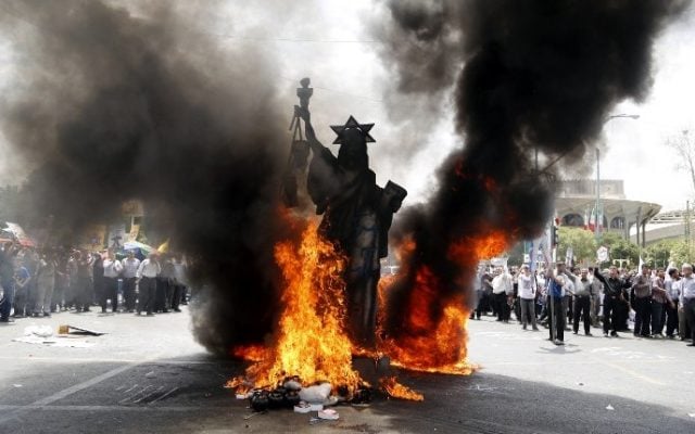 A statue depicting the US Statue of Liberty decorated with a Star of David on its head is set ablaze by Iranian protestors during a parade marking al-Quds (Jerusalem) Day in Tehran on July 1, 2016.
(Atta Kenare/AFP) A statue depicting the US Statue of Liberty decorated with a Star of David on its head is set ablaze by Iranian protestors during a parade marking al-Quds (Jerusalem) Day in Tehran on July 1, 2016.
(Atta Kenare/AFP)