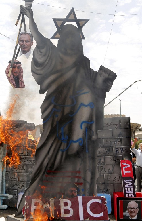 A statute depicting the Statue of Liberty decorated with a Star of David on its head and holding portraits of former British prime minister Tony Blair and Saudi Foreign Minister Adel al-Jubeir is set ablaze by Iranian protesters during a parade marking al-Quds (Jerusalem) Day in Tehran on July 01, 2016. (AFP photo) Tens of thousands joined pro-Palestinian rallies in Tehran, as the annual Quds Day protests take on broader meaning for a region mired in bitter disputes and war. On the bottom R a portrait of Australian born media magnate Rupert Murdoch. / AFP PHOTO / ATTA KENARE A statute depicting the Statue of Liberty decorated with a Star of David on its head and holding portraits of former British prime minister Tony Blair and Saudi Foreign Minister Adel al-Jubeir is set ablaze by Iranian protesters during a parade marking al-Quds (Jerusalem) Day in Tehran on July 01, 2016. (AFP photo) Tens of thousands joined pro-Palestinian rallies in Tehran, as the annual Quds Day protests take on broader meaning for a region mired in bitter disputes and war. On the bottom R a portrait of Australian born media magnate Rupert Murdoch. / AFP PHOTO / ATTA KENARE