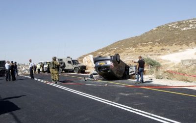 Israeli police look for evidence at the scene where Miki Mark was killed and three members of his family were wounded when a Palestinian terrorist opened fire on their car, on July 1, 2016, south of Hebron. (AFP/Hazem Bader)