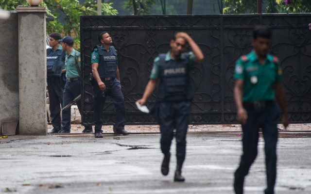 Bangladeshi policemen exit from a gate leading to an upscale cafe in Dhaka on July 3, 2016 a day after a bloody siege ended with the death of 20 foreign hostages. (AFP/ROBERTO SCHMIDT)