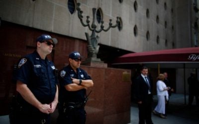 New York Police Department (NYPD) officers stand guard outside the synagogue as funeral services are held for Nobel laureate and Holocaust survivor Elie Wiesel in New York, July 3, 2016. (AFP/Kena Betancur)