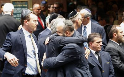 People embrace outside the Fifth Avenue Synagogue during the funeral for Nobel laureate and Holocaust survivor Elie Wiesel on July 3, 2016 in New York.  (AFP PHOTO / KENA BETANCUR)