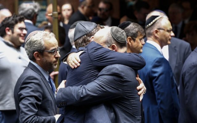 People embrace outside the Fifth Avenue Synagogue during the funeral for Nobel laureate and Holocaust survivor Elie Wiesel on on July 3, 2016 in New York. (AFP PHOTO / KENA BETANCUR)