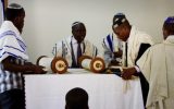 Rabbi Gershom Sizomu, second left, prepares to read the Torah during a Shabbat service among the Abayudaya Jewish community, in a village near Mbale, eastern Uganda, July 2, 2016. (AFP/Michael O'Hagan)