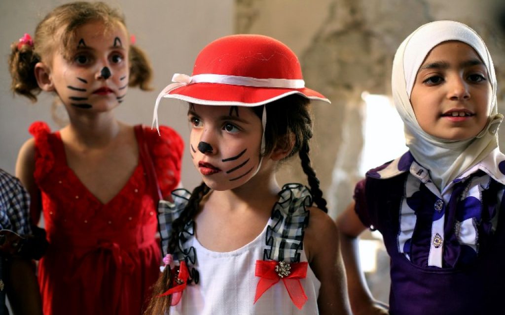 Syrian children gather during an activity organised by a charity group in Jobar, a rebel-held district on the eastern outskirts of the capital Damascus, ahead of Eid al-Fitr holyday in the war-torn country on July 5, 2016.(AFP PHOTO / AMER ALMOHIBANY)
