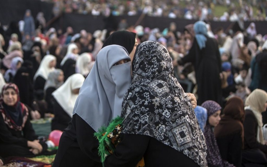 Veiled Palestinian women embrace during the morning Eid al-Fitr prayers in Gaza city on July 6, 2016.
Muslims worldwide celebrate Eid al-Fitr marking the end of the fasting month of Ramadan. (AFP PHOTO / MAHMUD HAMS)