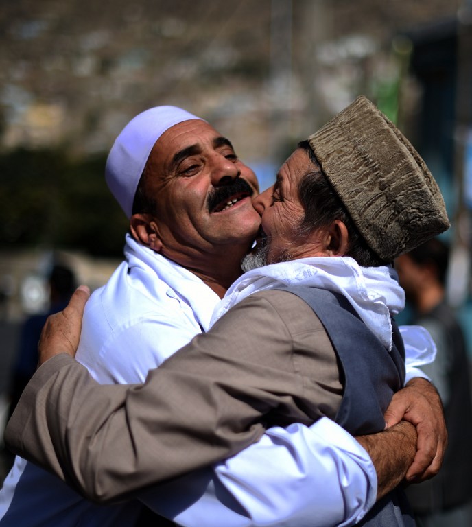 Afghan Muslims hug each other after offering prayers at the start of the Eid al-Fitr holiday which marks the end of Ramadan, at the Shah-e Do Shamshira mosque in Kabul on July 6, 2016. (AFP PHOTO / WAKIL KOHSAR)