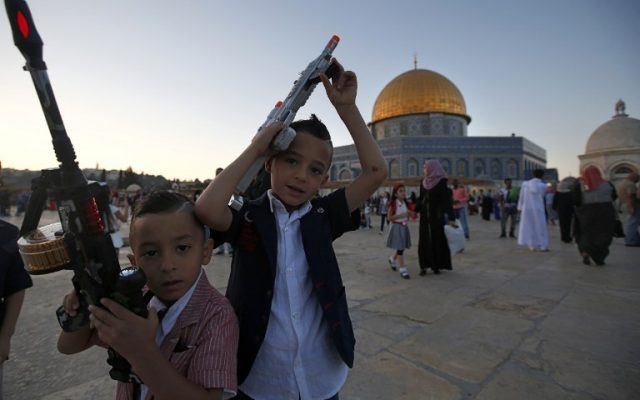 Palestinian boys hold toy guns on the Temple Mount during Eid al-Fitr on July 6, 2016.(AFP PHOTO / AHMAD GHARABLI)