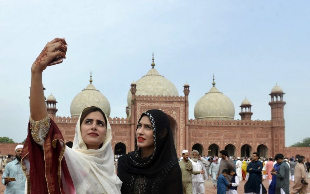 Pakistan Muslim women take selfie photographs after offering Eid al-Fitr prayers at the Badshahi Masjid in Lahore on July 6, 2016. (AFP PHOTO / ARIF ALI)