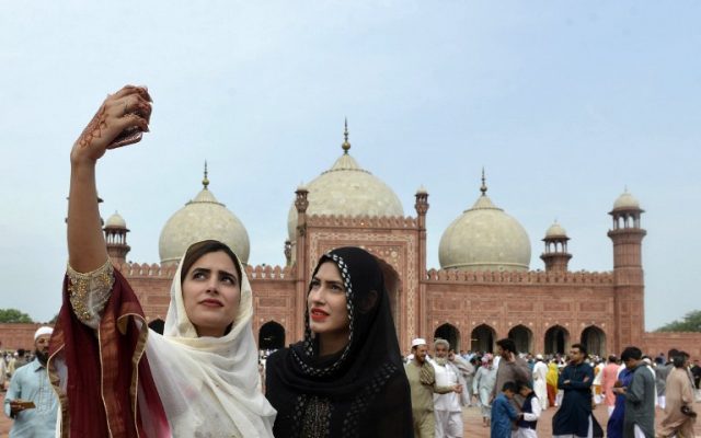 Pakistan Muslim women take selfie photographs after offering Eid al-Fitr prayers at the Badshahi Masjid in Lahore on July 6, 2016. (AFP PHOTO / ARIF ALI)