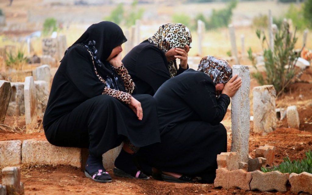 Syrian women mourn at the grave of a relative in the rebel-held area of Daraa, in southern Syria, on the first day of the Eid al-Fitr holiday that marks the end of the holy Muslim fasting month of Ramadan on July 6, 2016. (AFP PHOTO / MOHAMAD ABAZEED)