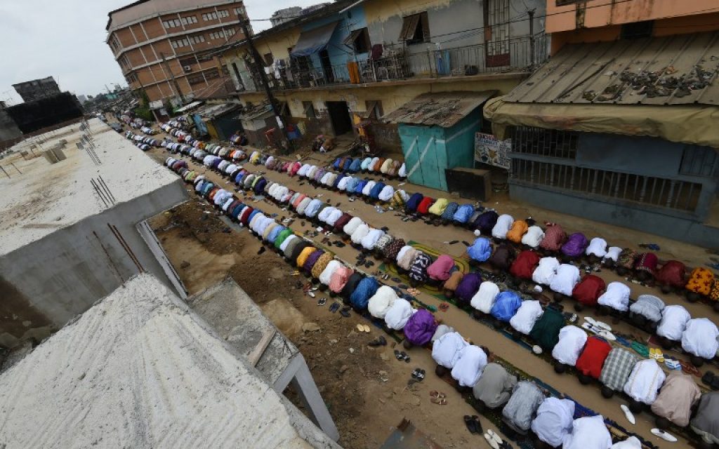 Men pray in a street near a mosque in Abidjan on July 6, 2016 as they celebrate Eid al-Fitr which marks the end of the Islamic holy fasting month of Ramadan (AFP PHOTO / SIA KAMBOU)