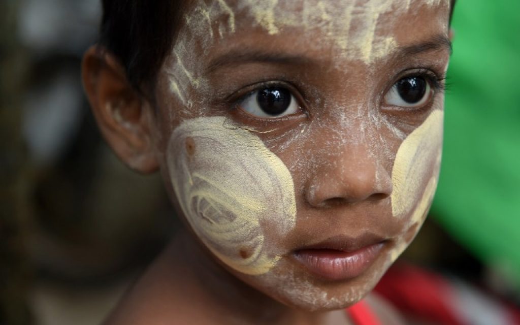 Myanmar child wearing a "thanaka", a traditional facial cosmetic, waits for alms outside a mosque in Yangon on July 6, 2016 on the eve of Eid al-Fitr celebrations.(AFP PHOTO / ROMEO GACAD)