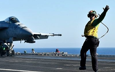 A shooter gives the ready to go signal to An F/A-18E Super Hornet on the US navy's super carrier USS Dwight D. Eisenhower (CVN-69) ("Ike") in the Mediterranean Sea on July 6, 2016. (AFP PHOTO / ALBERTO PIZZOLI)