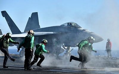 Sailors get ready around an F/A-18E Super Hornet on the US navy's super carrier USS Dwight D. Eisenhower (CVN-69) ("Ike") in the Mediterranean Sea on July 6, 2016. (AFP PHOTO / ALBERTO PIZZOLI)