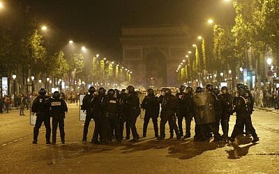 French riot police stand near the Arc de Triomphe after the Euro 2016 final football match between Portugal and France on the Champs Elysees in Paris, on July 10, 2016. (AFP PHOTO/GEOFFROY VAN DER HASSELT)