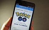This photo illustration taken in Tokyo on July 13, 2016 shows the Pokemon official site through a Japanese internet website announcing the latest information for "Pokémon GO".(AFP PHOTO / KAZUHIRO NOGI )