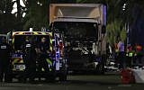 Police officers and rescue workers stand near a van that plowed into a crowd leaving a fireworks display in the French Riviera town of Nice on July 14, 2016. (Valery Hache/AFP)