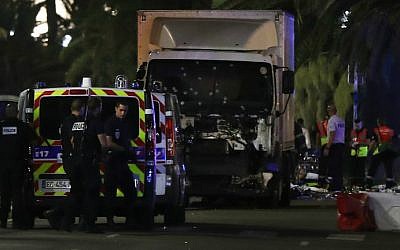 Police officers and rescue workers stand near a van that plowed into a crowd leaving a fireworks display in the French Riviera town of Nice on July 14, 2016. (Valery Hache/AFP)