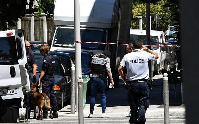 French police officers and French gendarmes stand next to a truck in a street of Nice on July 15, 2016, near the building where the man who drove a truck into a crowd watching a fireworks display, the day before, reportedly lived. (AFP Photo/Anne-Christine Poujoulat)