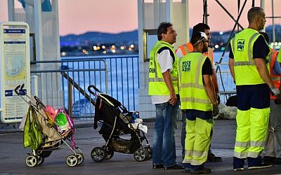 Garbage collectors gather near abandoned baby strollers, as they prepare to clean the Promenade des Anglais on July 15, 2016 in Nice, on the day following the deadly Bastille Day celebration attack. (AFP PHOTO/GIUSEPPE CACACE)