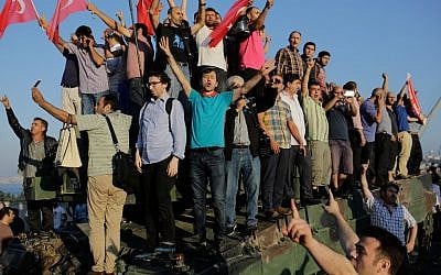 People celebrate on a tank after they took over military position on the Bosphorus bridge in Istanbul on July 16, 2016, folowing a failed army coup. (AFP PHOTO/Yasin AKGUL)