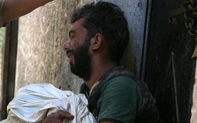 A Syrian man mourns the death of a child following reported air strikes on July 16, 2016 in the rebel-controlled neighborhood of Saleheen in the northern Syrian city of Aleppo.(AFP PHOTO / THAER MOHAMMED)