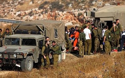 IDF soldiers and medical personnel at the site of an accidental grenade explosion near the village of Majdal Shams in the Golan Heights on July 17, 2016. (AFP PHOTO / JALAA MAREY)