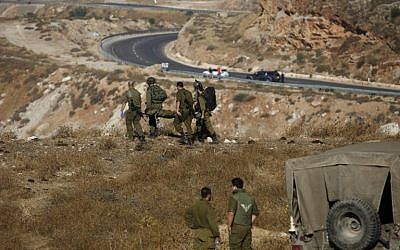 Israeli soldiers evacuate a wounded soldier following a grenade explosion near the village of Majdal Shams in the Golan Heights on July 17, 2016. (AFP / JALAA MAREY)