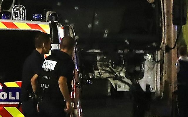 Police officers stand near the truck that plowed into a crowd leaving a fireworks display in the French Riviera city of Nice on July 14, 2016. (AFP / VALERY HACHE) Police officers stand near the truck that plowed into a crowd leaving a fireworks display in the French Riviera city of Nice on July 14, 2016. (AFP / VALERY HACHE)