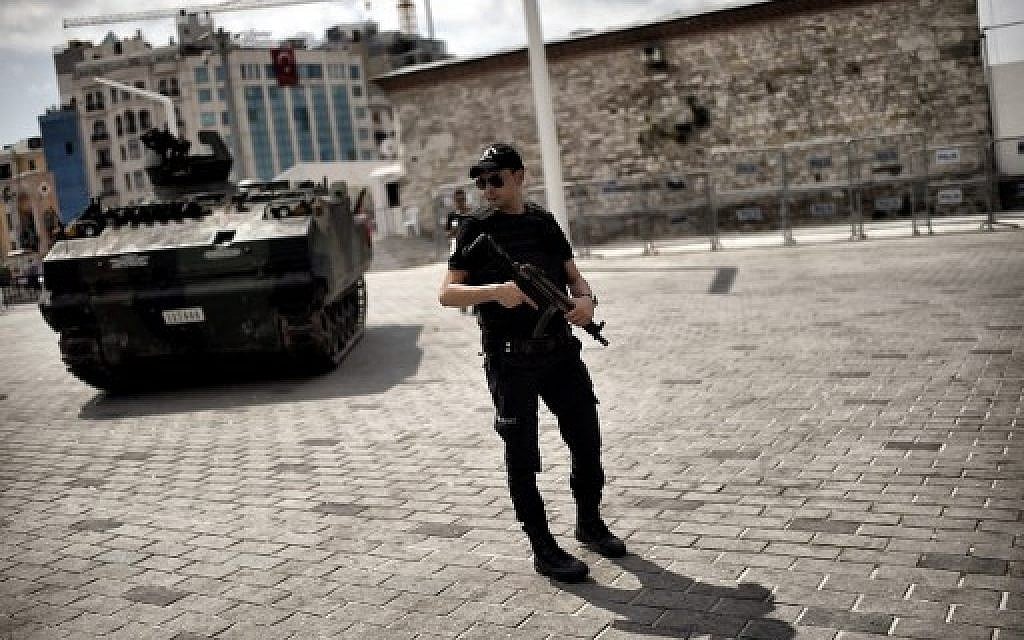 A police officer stands next to an armoured vehicle that was used by soldiers during the coup attempt at Taksim square in Istanbul on July 17, 2016. (AFP PHOTO / ARIS MESSINIS)