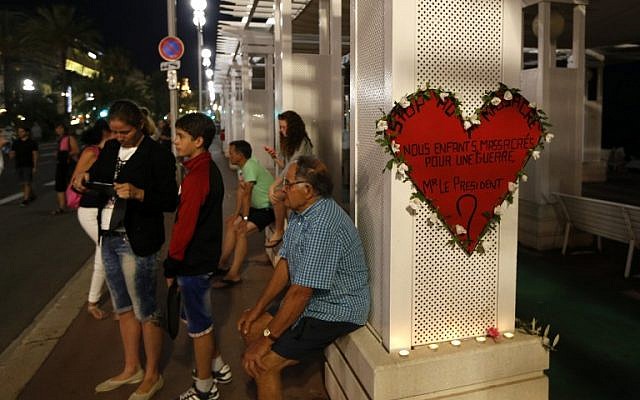 A man sits next to a heart-shaped sign reading "Stop the massacre...Our children massacred for a war...Mr. President?" on the Promenade des Anglais in Nice on July 17, 2016.(AFP PHOTO / Valery HACHE) A man sits next to a heart-shaped sign reading "Stop the massacre...Our children massacred for a war...Mr. President?" on the Promenade des Anglais in Nice on July 17, 2016.(AFP PHOTO / Valery HACHE)