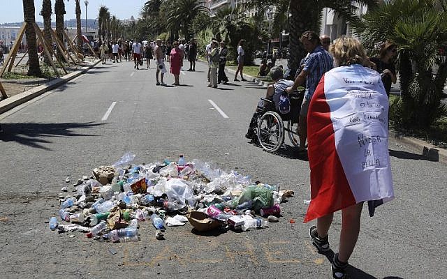 People throw garbage on the Promenade des Anglais seafront in Nice, at the site where the 31-year-old Tunisian, Mohamed Lahouaiej-Bouhlel, drove a truck into a crowd watching a fireworks display on Bastille Day, was killed by the police, on July 18, 2016. The message reads "coward." (AFP/ Valery HACHE) People throw garbage on the Promenade des Anglais seafront in Nice, at the site where the 31-year-old Tunisian, Mohamed Lahouaiej-Bouhlel, drove a truck into a crowd watching a fireworks display on Bastille Day, was killed by the police, on July 18, 2016. The message reads "coward." (AFP/ Valery HACHE)