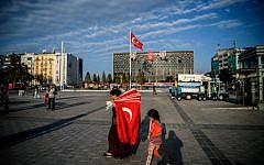 A woman prepares to sell Turkish flags in Taksim square on July 18, 2016 in Istanbul. (AFP PHOTO / OZAN KOSE)