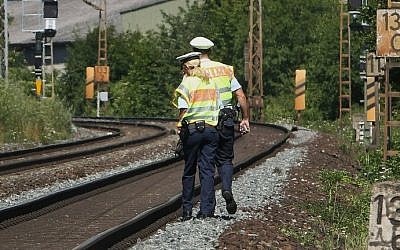Police officers walk along train tracks in Wuerzburg southern Germany on July 19, 2016, a day after a man attacked train passengers with an ax. (AFP PHOTO / DANIEL ROLAND)