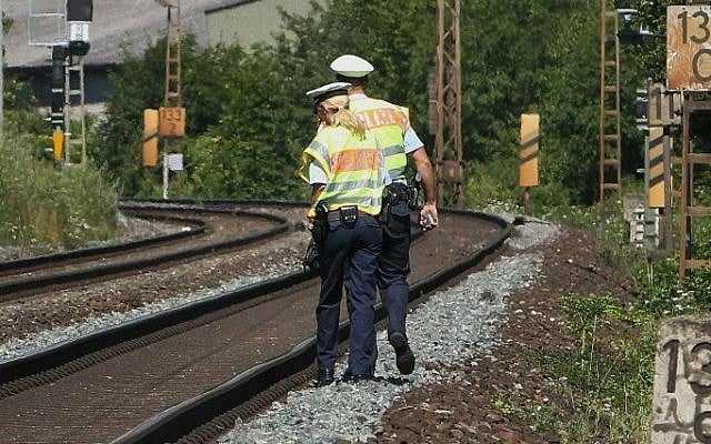 Police officers walk along train tracks in Wuerzburg southern Germany on July 19, 2016 a day after a man attacked train passengers with an axe.
(AFP / DANIEL ROLAND) Police officers walk along train tracks in Wuerzburg southern Germany on July 19, 2016 a day after a man attacked train passengers with an axe.
(AFP / DANIEL ROLAND)