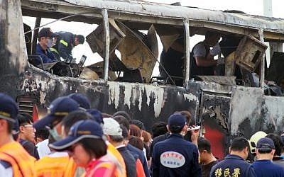 Investigators inspect a bus carrying tourists from mainland China that crashed and caught fire along an expressway on its way to the airport in Taiwan's city of Taoyuan on July 19, 2016. (AFP PHOTO/SAM YEH)