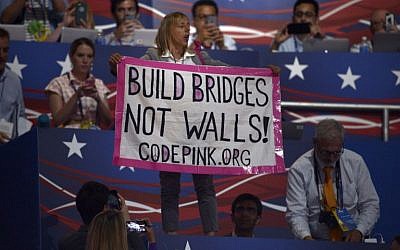 A protester holds up a sign as Republican presidential candidate Donald Trump speaks during the Republican National Convention on July 21, 2016, in Cleveland, Ohio. (AFP PHOTO/Brendan Smialowski)
