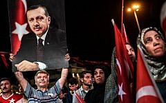 A man holds up a photo of Turkey's President Recep Tayyip Erdogan during a pro-Erdogan rally in Taksim Square in Istanbul on July 22, 2016, following the failed military coup attempt of July 15. (AFP/Ozan Kose)