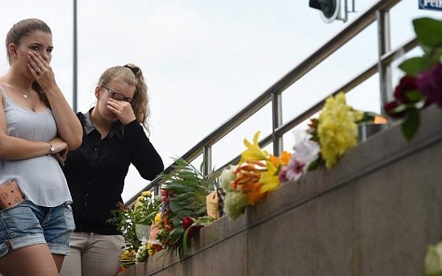 Two young women mourn at an underground station near the Olympia-Einkaufszentrum shopping center on July 23, 2016, one day after a shooting attack at the shopping center in Munich killed nine people. (AFP/ Christof Stache)