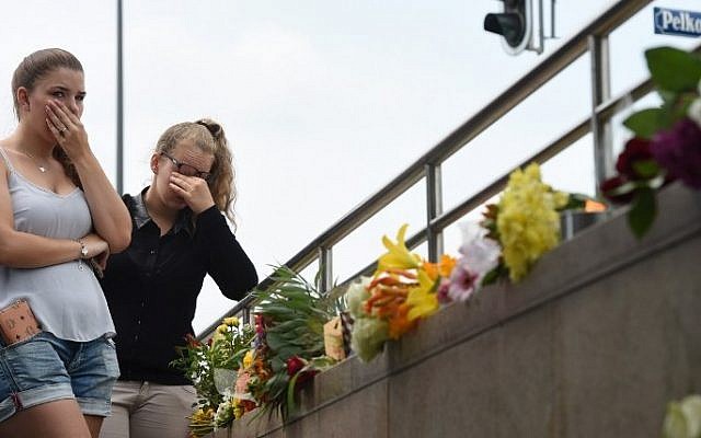 Two young women mourn at an underground station near the Olympia-Einkaufszentrum shopping centre on July 23, 2016, one day after the attack at the shopping centre in Munich, southern Germany. (AFP PHOTO / Christof Stache) Two young women mourn at an underground station near the Olympia-Einkaufszentrum shopping centre on July 23, 2016, one day after the attack at the shopping centre in Munich, southern Germany. (AFP PHOTO / Christof Stache)