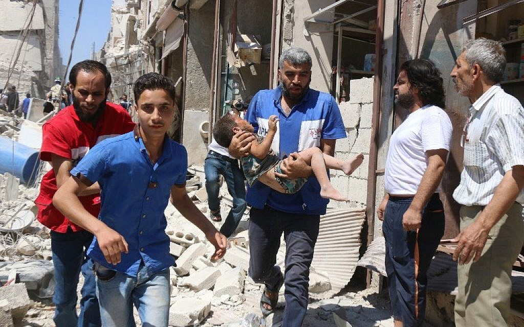 A Syrian civil defense volunteer carries a wounded child following a reported airstrike on the rebel-held neighborhood of Qatirji in the northern city of Aleppo on July 23, 2016. (AFP PHOTO/Thaer Mohammed)